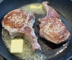 two pieces of meat in a frying pan with butter