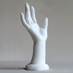 a white plastic hand holding something in the air