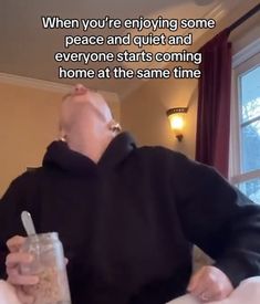 a man sitting at a table with a drink in his hand and the caption reads, when you're enjoying some peace and quiet and everyone starts coming home at the same time