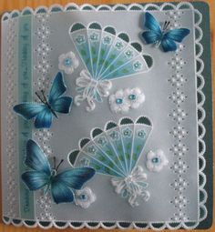 some blue butterflies are sitting on top of a doily with white flowers and lace