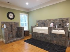 a large bathroom with two sinks and three urinals on the wall next to each other