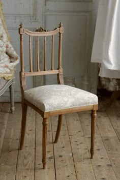 an old chair is sitting on the wooden floor