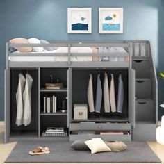 a bunk bed with drawers underneath it and clothes hanging on the shelves above them in a blue room