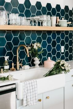 a kitchen with green hexagonal tiles on the wall