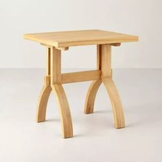 a small wooden table sitting on top of a white floor