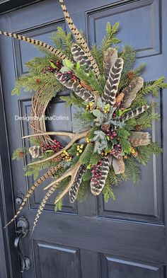 a wreath with feathers and berries hanging on the front door to decorate it for christmas