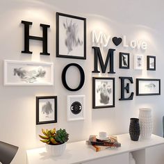 a white table topped with pictures and vases on top of it next to a wall