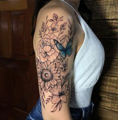 a woman's arm with flowers and a butterfly on the back of her shoulder