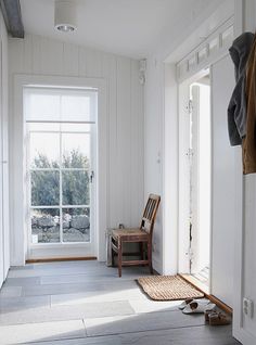 an empty room with white walls and wood flooring on the side, there is a wooden bench in the middle