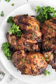 grilled chicken with parsley on a white plate