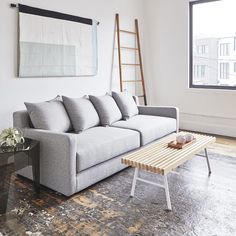 a living room with a couch, coffee table and ladder