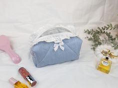 This beautifully handcrafted makeup bag is perfect for organizing your beauty essentials. Featuring a classic blue and white striped cotton fabric, adorned with delicate lace trim and a satin bow, it adds a touch of elegance to your everyday routine. The bag is fully lined and closes with a secure zipper, making it ideal for both travel and daily use. Its compact size fits easily in your handbag or suitcase, and it can also be used to store small accessories. Add a stylish and functional piece to your beauty routine with this elegant, handmade cosmetic pouch! Size: Mini Size: 13 cm x 10 cm x 7 cm (5.1" x 3.9" x 2.7") Medium Size: 18 cm x 10 cm x 8 cm (7.0" x 3.9" x 3.1") Large Size: 22 cm x 12 cm x 10 cm (8.6" x 4.7" x 3.9") X-Large (Travel) Size: 29 cm x 15 cm x 12 cm (11.4" x 5.9" x 4.7" Blue Makeup Bag, Stylish Makeup, Small Makeup Bag, Handmade Cosmetics, Everyday Routine, Small Makeup, Bag With Zipper, Blue Makeup, Toiletry Storage