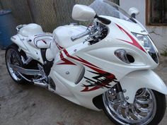 a white and red motorcycle parked next to a building