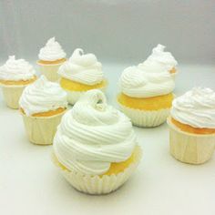 cupcakes with white frosting sitting on a table