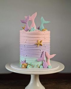 a multi - colored cake with mermaid tail decorations