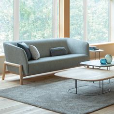 a living room with two couches and a coffee table in front of large windows