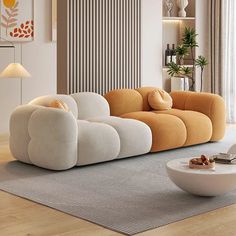 an orange and white couch sitting on top of a wooden floor next to a table