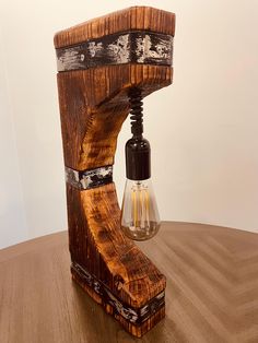 a lamp made out of wood with a light bulb attached to the end of it