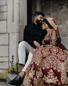 a man and woman sitting next to each other on the steps in front of a building