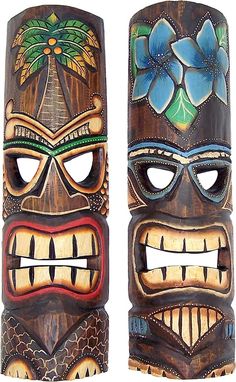 two wooden tiki masks with flowers and leaves on them