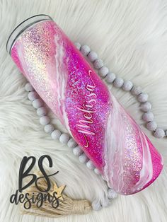 a pink and white tube with glitter on it next to a beaded necklace that says, be awesome