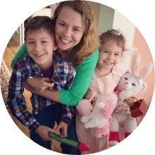 a woman and two children are smiling at the camera with stuffed animals in front of them