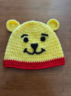 a crocheted bear hat on top of a wooden table