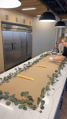 two women working on a long table in a kitchen