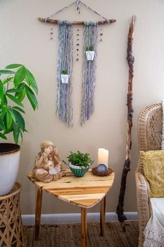 a small table with a candle on it next to a potted plant and some branches