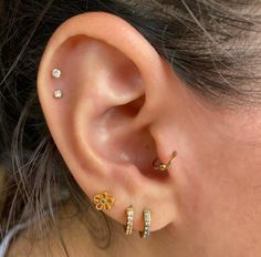 a close up of a person's ear with three different types of piercings