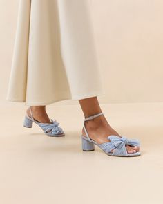 Pleated knot heeled sandal in a light blue fabric. Padded footbed with gold stamped logo. Open toe with adjustable buckle ankle strap. 2 inch heel. Made with all vegan materials. Blue Flat Wedding Shoes, Wedding Flats For Bride, Blue Heels Wedding, Dahlia Black, Cafe Wedding, Light Blue Fabric, Knot Bow, Wedding Boards, Wedding Shoes Flats