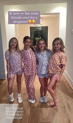 four girls in matching pajamas posing for the camera with a sign above them that says & now ev has some friends over for a sleepover