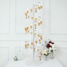 there are many glasses on the table with flowers