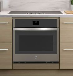 an oven built into the side of a kitchen counter top with drawers and cupboards