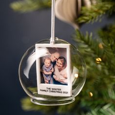 an ornament hanging from a christmas tree with a family photo in the center