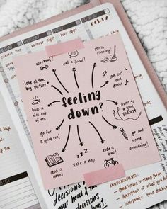 an open notebook with stickers on it and the words feeling down written in pink