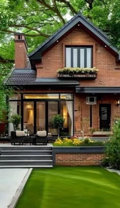 a large brick house sitting in the middle of a lush green yard