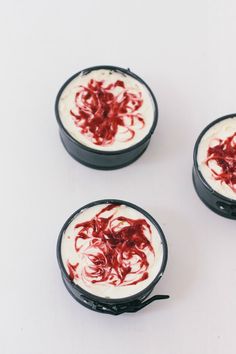 three desserts with white and red icing on them