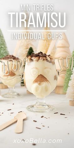 two glasses filled with ice cream sitting on top of a table next to christmas trees