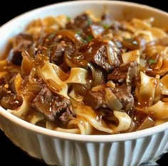 a white bowl filled with pasta and beef