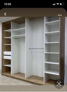 an empty walk in closet with white shelves and wood trimmings on the walls