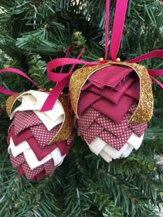 two red and white ornaments hanging from a christmas tree with pink ribbon on it's ends