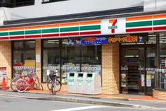 a store front with bicycles parked outside it on the side of the street in front of them