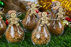 some glass vases filled with food on top of a green grass covered ground next to christmas decorations