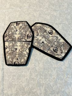 two pieces of cloth with black and white designs on them sitting on top of a table