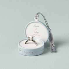 an engagement ring in a box with a tassel