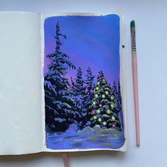 an open notebook with a christmas tree on it and two pencils next to it