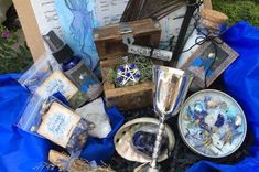 a table topped with lots of items like candles and other things sitting on top of a blue tarp