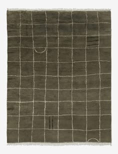 an area rug with squares and lines on the ground, in dark olive green color