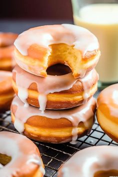 glazed donuts with icing on a cooling rack next to a glass of milk